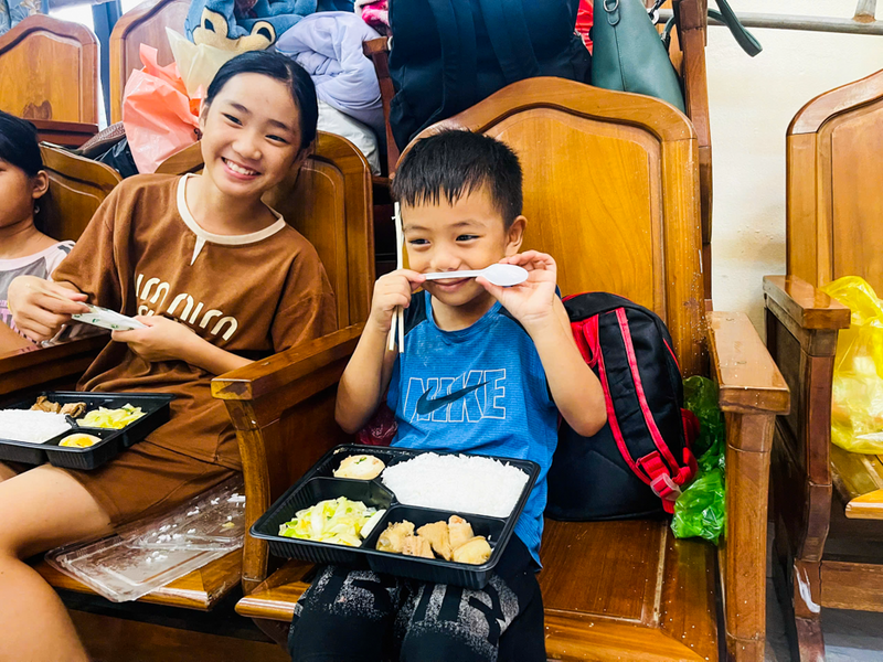 Các em nhỏ vui cười đón nhận suất ăn miễn phí tại khu tránh trú bão. Ảnh: Người dân cung cấp