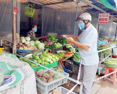 Thành viên tổ đi chợ thay tất bật mua hàng hóa cho người dân.