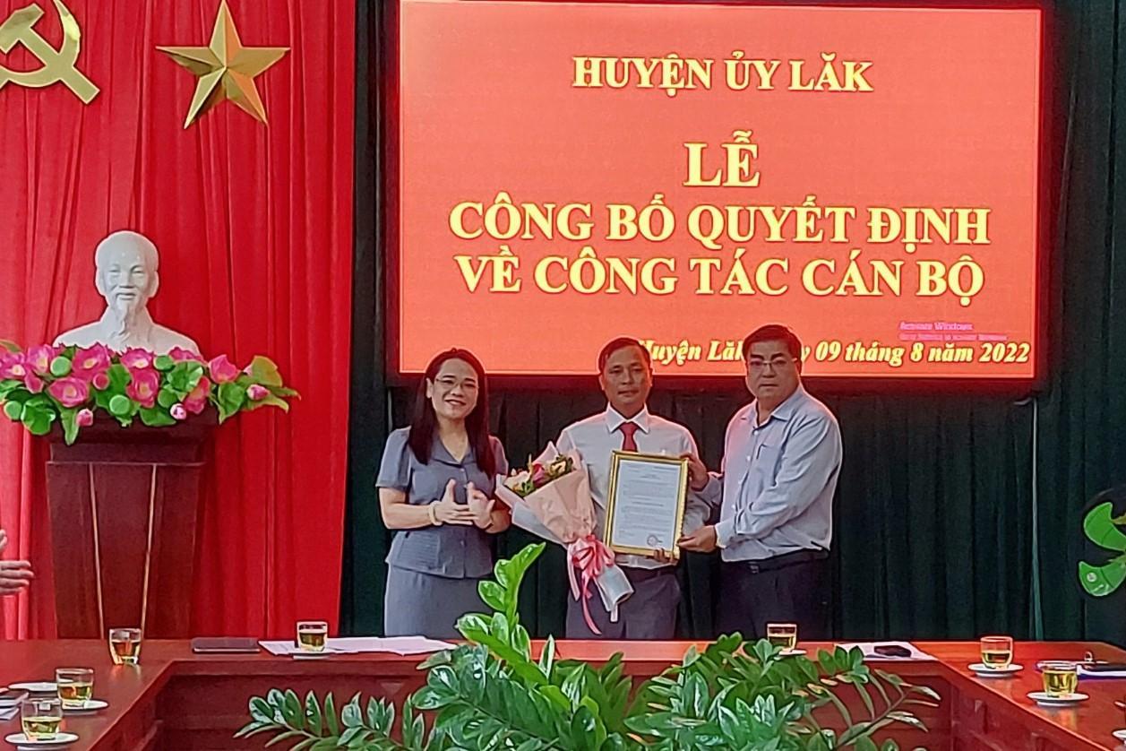 Bí thư Huyện ủy Lắk Võ Ngọc Tuyên (bên phải) và Phó Bí thư Thường trực Huyện ủy Lắk Đào Thị Thanh An (bên trái) trao Quyết định điều động và hoa cho đồng chí Niê Y Chiến.