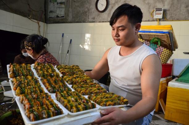 Anh Nguyễn Minh Thao bên những khay lươn cuộn vừa làm. Ảnh: Dương Đình Tường.