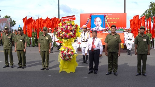 Ông Đinh Khắc Đính - Phó Chủ tịch Ban Chấp hành Trung ương Hội Nông dân Việt Nam, Ủy viên Ban Chỉ đạo “Thực hiện phong trào toàn dân bảo vệ an ninh Tổ quốc” Trung ương - tặng hoa cho Lực lượng bảo vệ an ninh, trật tự ở cơ sở TP Vũng Tàu. Ảnh: Thành An