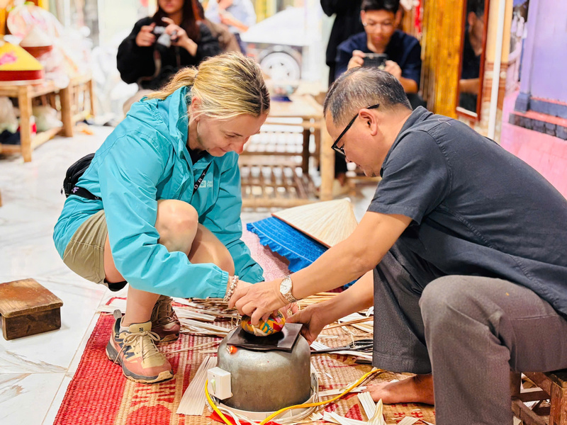 Mỗi tháng, điểm trải nghiệm làm nón của ông Tuy đón hàng trăm đoàn du khách nước ngoài về tham quan. Ảnh: Nhật Chi