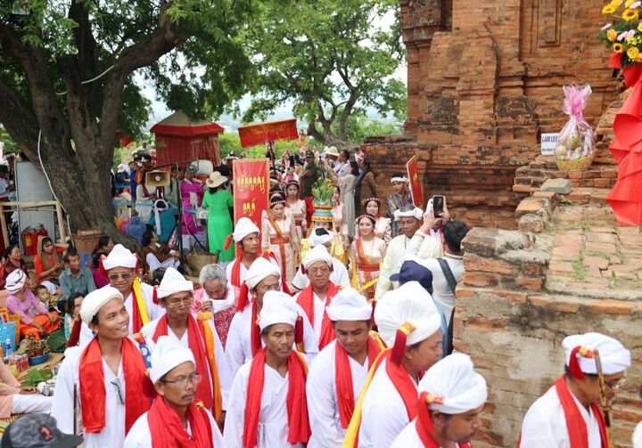 Đoàn chức sắc và bà con đồng bào Chăm trong trang phục truyền thống rước y trang lên đền tháp chính Pô Klong Garai. Ảnh: Mai Đông - Thanh Sơn.